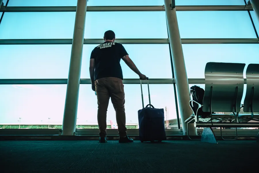 Una persona viajando con su maleta por una terminal luminosa.
